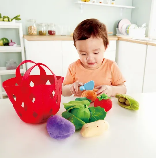 Toddler cooking with a play kitchen set