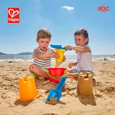 海辺で砂遊びのおもちゃを使って遊ぶ子ども