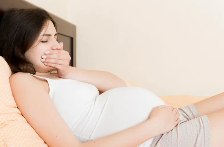 Pregnant mother touching her tight, firm abdomen