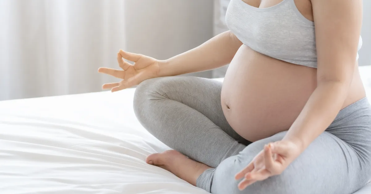 Expectant mother meditating to relieve stress